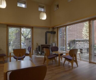 Lounge with wooden tables, chairs and large windows at Yunomori Okunikko Yumoto Onsen Tochigi