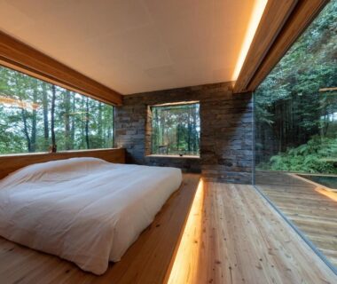 Room with low bed, floor-to-ceiling windows and woodland view at Kaze no Mori, Oku-Takeo Onsen, Saga, Kyushu