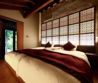 Wood-framed bedroom with beds, shoji screens and garden light at Okuyugawara YUI, Kanagawa