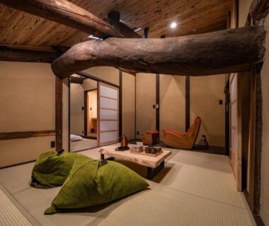 Tatami room with low table, green cushions, shoji doors and exposed wooden beams at Wabi Sabi in Himeji