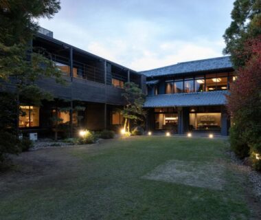 Dusk view of two-story ryokan with lit windows and garden courtyard at Kotan Ureshino, Saga