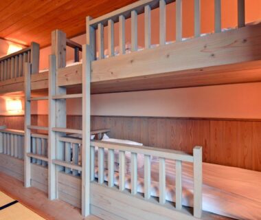 Wooden bunk beds and futons in a tatami room at Morimi Onsen, Kyūshū, Ōita