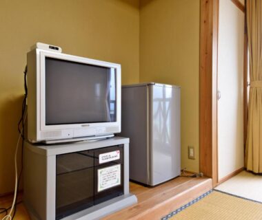 Tatami room with CRT television, mini fridge and shoji door at Yasuragi no Sato Yamakuni, Ōita
