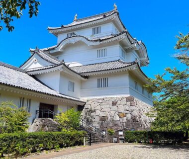 White multi-tiered castle-style building with stone base and tiled roofs at Awa Resort Ryokan Rinkai Garyū in Chiba, Kantō