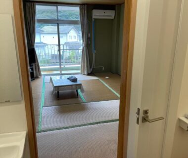 Tatami room with low table, balcony sliding door and sink near entrance at Awa Resort Ryokan Rinkai Garyū Chiba