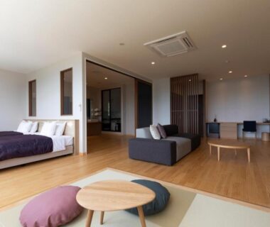 Open room with tatami area, low table, bed and sofa at Miyajima Hanare no Yado IBUKU, Hiroshima