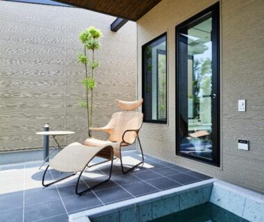 Tiled outdoor terrace with stone soaking tub and lounge chair at Miyajima Hanare no Yado IBUKU, Hiroshima