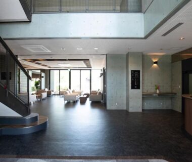 Sunlit lobby with seating, staircase and reception area at Miyajima Hanare no Yado IBUKU, Hiroshima