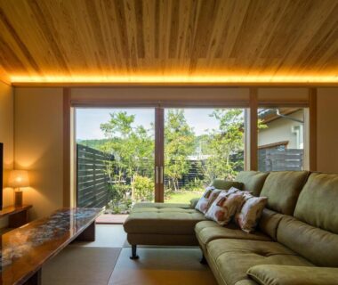 Relaxing tatami lounge with sofa, low table and sliding doors opening to a small garden at Shukubō Shingetsu, Saga
