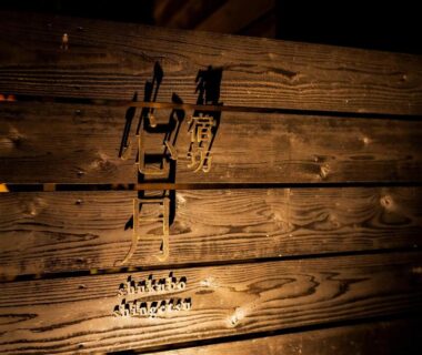 Warm-lit wooden signboard with Shukubō Shingetsu lettering at a ryokan in Saga, Kyūshū, Japan