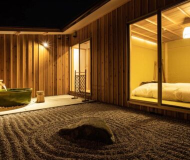 Outdoor wooden bath beside raked gravel courtyard and room with futon at Temple Hotel Kannonin, Gunma, Kantō