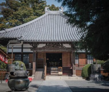 Front courtyard and main hall of Kannonin temple hotel with incense burner and stone lanterns in Gunma, Kantō