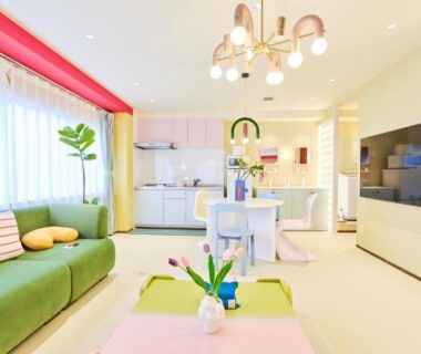 Pastel lounge with green sofa, kitchenette, dining area and TV at TORA HOTEL Okachimachi Tokyo