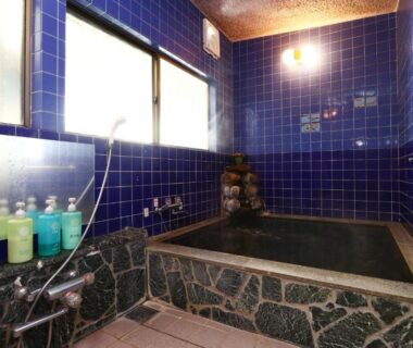 Indoor stone-lined bath with blue tiles at Fujimi Sansō in Shizuoka, Chūbu region