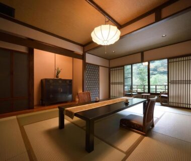 Traditional tatami room with low wooden table, floor chairs, shoji screens and garden view at Yama no Chaya, Kanagawa