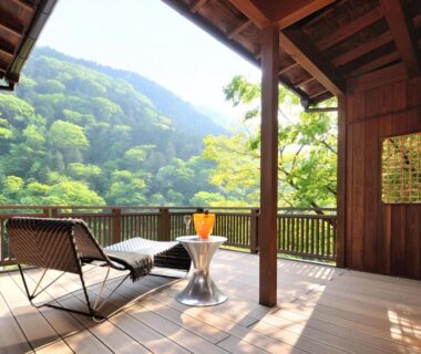 Wooden terrace with loungers and table overlooking green mountains at Yama no Chaya in Kanagawa