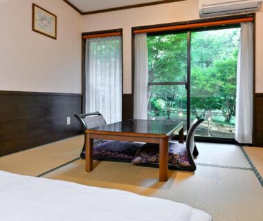 Tatami-floored room with low table and garden view at Kosugian Yamakawa Onsen, Kumamoto