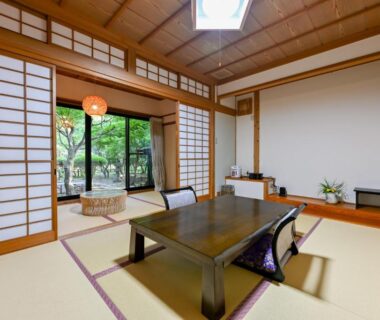 Traditional tatami room with low table, shoji screens and garden view at Kosugian Yamakawa Onsen Kumamoto