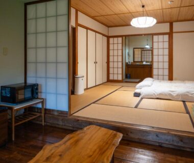 Tatami room with futon, shoji screens and low wooden table at 山荘 紗羅樹 Syaranoki Ōita