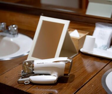 Wooden vanity with double sinks, mirror, hairdryer and toiletries at 山荘 紗羅樹 Syaranoki in Ōita