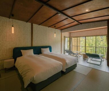 Tatami room with twin beds, sliding doors and balcony overlooking greenery at 巛-sen-Yugawara in Kanagawa
