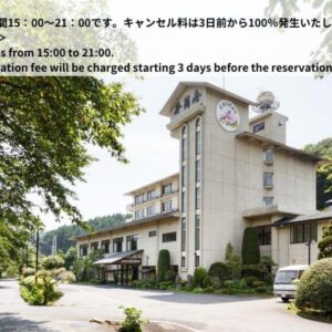 Exterior of Shikibu no Yakata Izutsuya with entrance, landscaped shrubs and tree-covered hillside, Fukushima Tōhoku