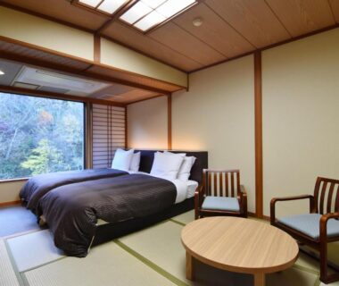 Tatami floor room with Western-style twin beds, low table and shoji screens at Shikibu no Yakata Izutsuya, Fukushima