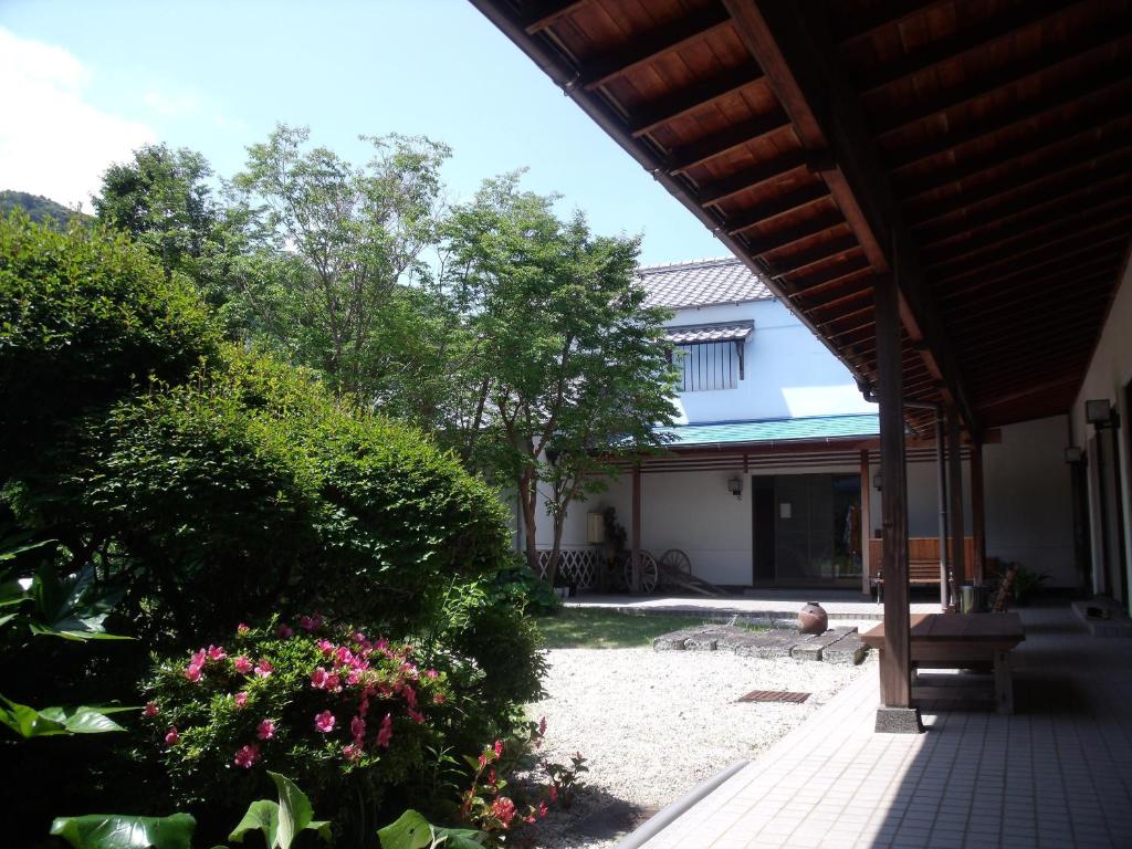 Engawa courtyard garden at Oyado Shinshima Shizuoka Wooden engawa veranda overlooking gravel courtyard with shrubs and entrance at Oyado Shinshima Shizuoka