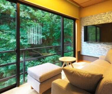 Sofa seating and ottoman by floor-to-ceiling windows at Oyado Zuiyō in Shizuoka