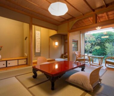 Traditional tatami room with low table, zabuton cushions and garden view through sliding glass doors