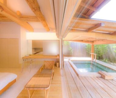 Indoor wooden bathing tub beside low bedding and sliding screens at Oyado Chikurintei, Saga, Kyūshū, Japan
