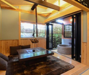 Traditional tatami room with low table and round indoor bath at Toku no Yado Fubuan, Ōita