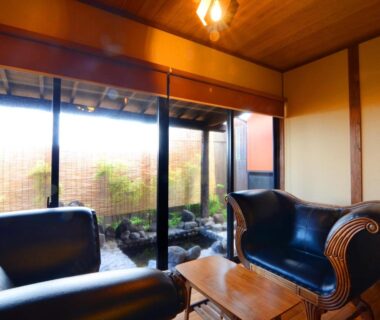 Seating area with leather sofas and garden view at Toku no Yado Fubuan in Ōita, Kyushu