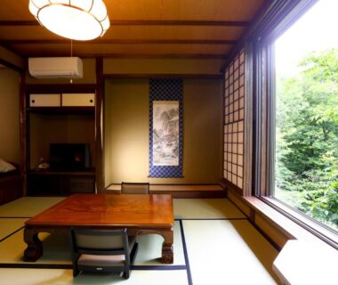 Traditional tatami room with low table overlooking greenery at Keikoku no Yu, Source Blanche de Shiga Kogen, Nagano