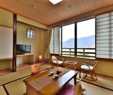 Tatami seating area with low table and shoji overlooking mountains at Tamano-yu Togura Kamiyamada Onsen Nagano
