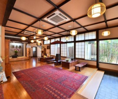 Spacious lobby with tatami seating, shoji screens, low tables and garden view at Tamano-yu, Nagano