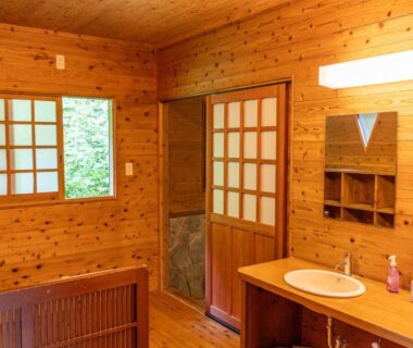 Wood-paneled dressing area with sink and shoji screens at Ōgi-sō, Kumamoto