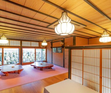 Traditional tatami dining room with low round tables, shoji screens and garden view at Ryokan Isobe Kyoto