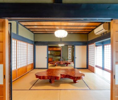 Spacious tatami room with low wooden table, shoji screens and tokonoma alcove at Ryokan Isobe Kyoto