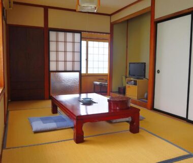 Traditional tatami room with low table, zabuton cushions, shoji and fusuma at 旅館FURUYA in Nagano