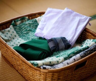 Woven basket with folded yukata and garments on tatami at Ryokan Ogita in Hokkaidō