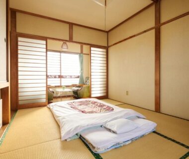 Traditional tatami room with folded futon, shoji screens and window seating at Ryokan Ogita near Shiraoi Station Hokkaido