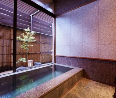 Indoor stone onsen bath with small garden view at Ryokan Kawana, Chiba, Kantō