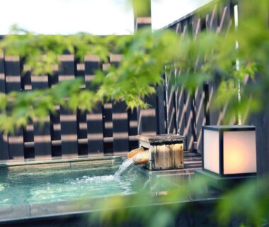 Outdoor onsen bath with lantern and wooden bucket at 旅館かわな in Chiba, Kantō