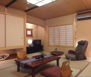 Traditional tatami room with low wooden table, zabuton cushions, shoji screens and massage chair, Ryokan Kawana, Chiba
