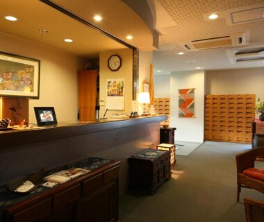 Reception desk with wooden counter, seating and shoe lockers at Ryokan Kawana, Chiba, Kantō