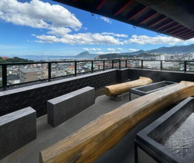 Rooftop footbath with wooden benches and stone basins at nihonryokan utsuwa beppukannnawa in Ōita