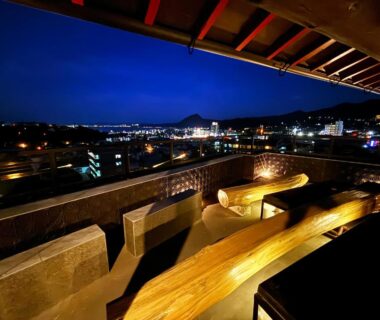 Outdoor wooden onsen bath and bench seating on balcony at Nihonryokan Utsuwa Beppukannnawa Beppu Ōita