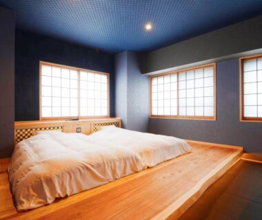 Raised wooden platform bed with futon and shoji screens in ryokan room