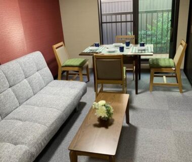 Seating area with sofa, coffee table and dining table at 明和荘 Mei Wa Inn in Kyoto